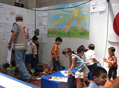 -Dobrovolník Červeného půlměsíce hlídá děti iráckých uprchlíků (Foto: AI)-