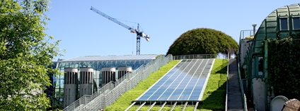 Moderní budova se zelenou střechou a solárními panely Foto: Depositphotos