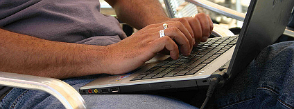 Muž s laptopem na klíně. Ilustrační foto: ElvertBarnes / Flickr