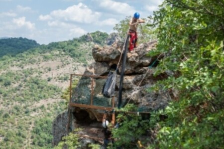  Dobromil Dobrev z organizace BirdLife Bulgaria přebírá vak s mládětem supa mrchožravého, jehož novým domovem se dočasně stane skalní hnízdo s překrásným výhledem na bulharské hory a řeku Ardu. Na snímku je vidět také roura, kterou budou ochranáři mláďata přikrmovat. Za deset až čtrnáct dnů pak otevřou pomocí kladky pletivovou zábranu a obě samičky vyletí do bulharských hor. 