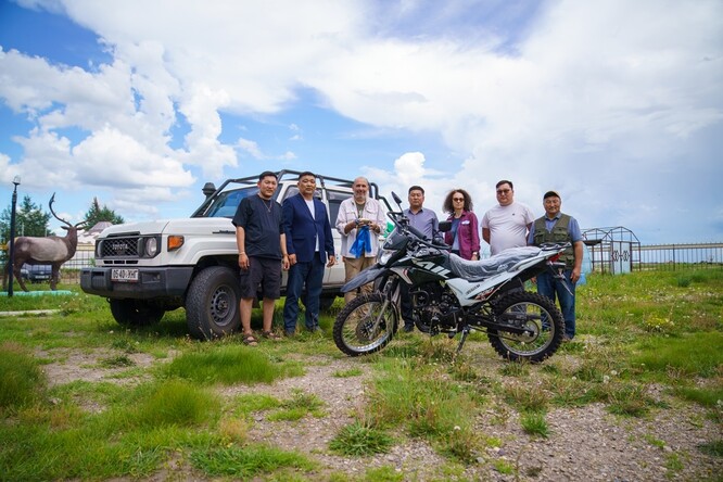Slavnostní předávání terénního auta a motocyklu. Zleva: pracovník organizace <i>Pomáháme jim přežít – Mongolsko</i> S. Dalajceren, ředitel národního parku Nömrög D. Naranbátar, Miroslav Bobek, guvernér okresu Chalchgol E. Bjambadžargal, mongolistka Veronika Kapišovská, předseda okresního zastupitelstva P. Itgeltögs, ředitel <i>Pomáháme jim přežít – Mongolsko</i> O. Ganbátar.