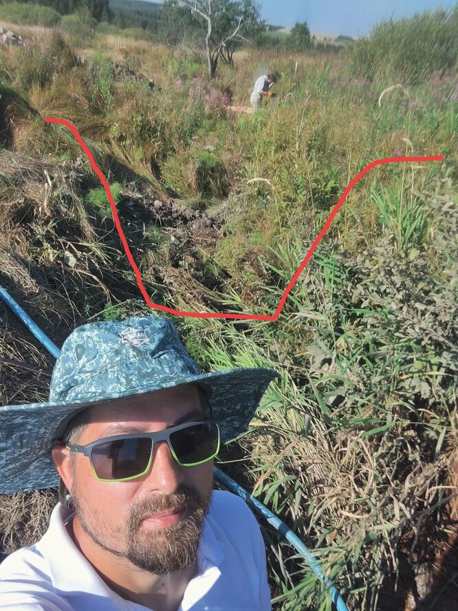Na první pohled to tak vzhledem k vysoké trávě nevypadá, ale za mnou je zhruba metr a půl hluboké koryto s opevněným dnem. Voda teče malým „čůrkem“ pouze po tom opevněném dně a celá niva potoka je kvůli tomu odvodněná.
