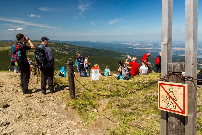Turisté odpočívající na Sněžce mimo vyznačená místa před umístěním plotu. 